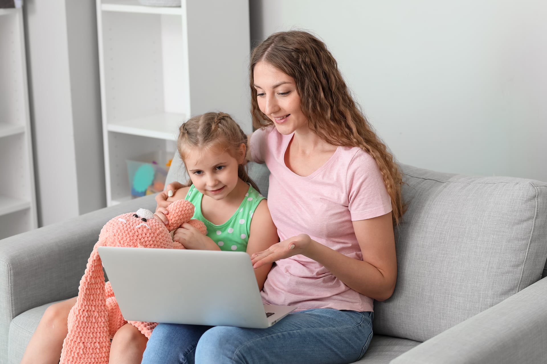 Parent participating in an online parenting support session, looking at a laptop.