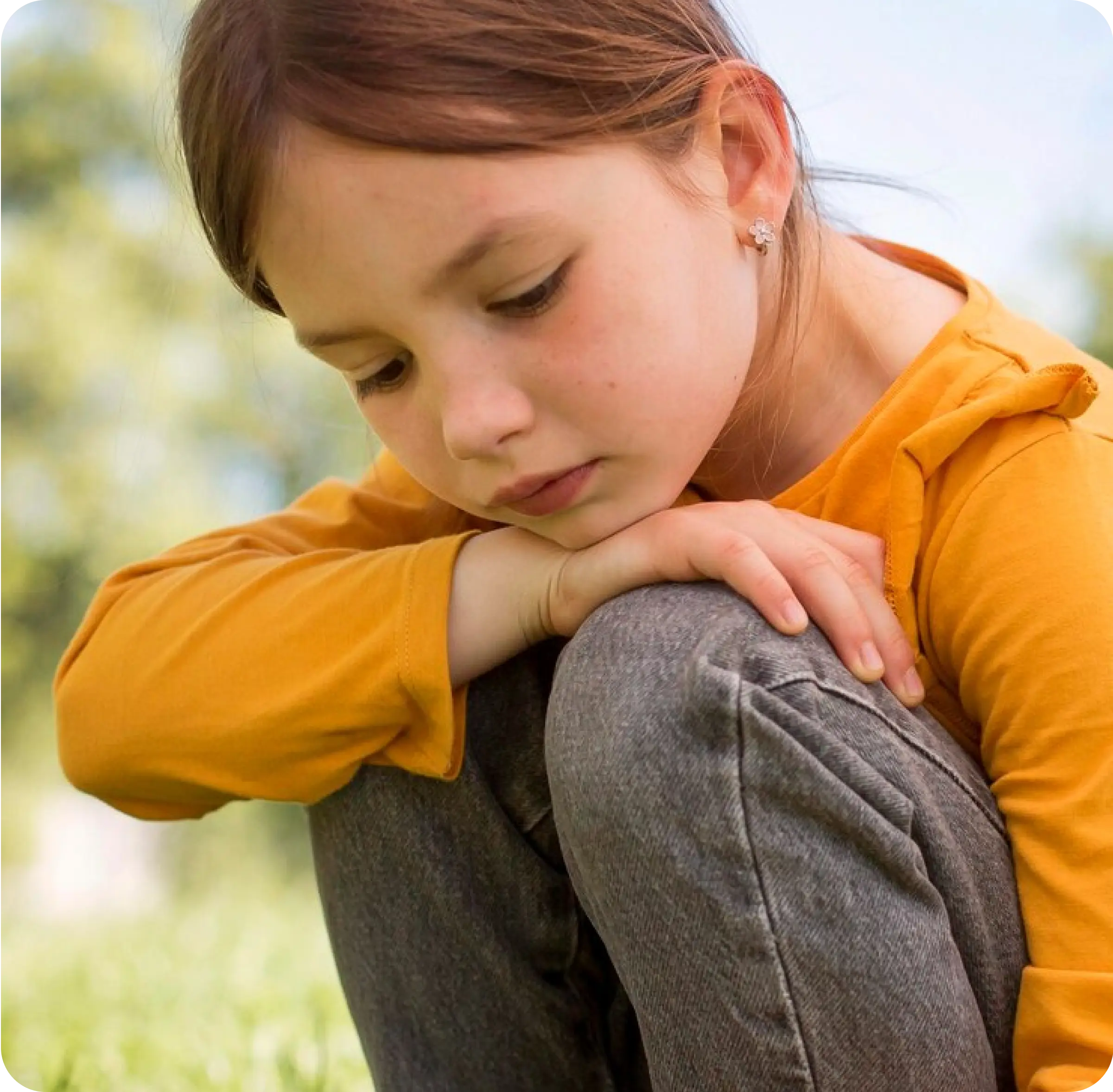 Sad girl resting her head, representing grief and child therapy services in Thornhill, Vaughan and nearby areas.