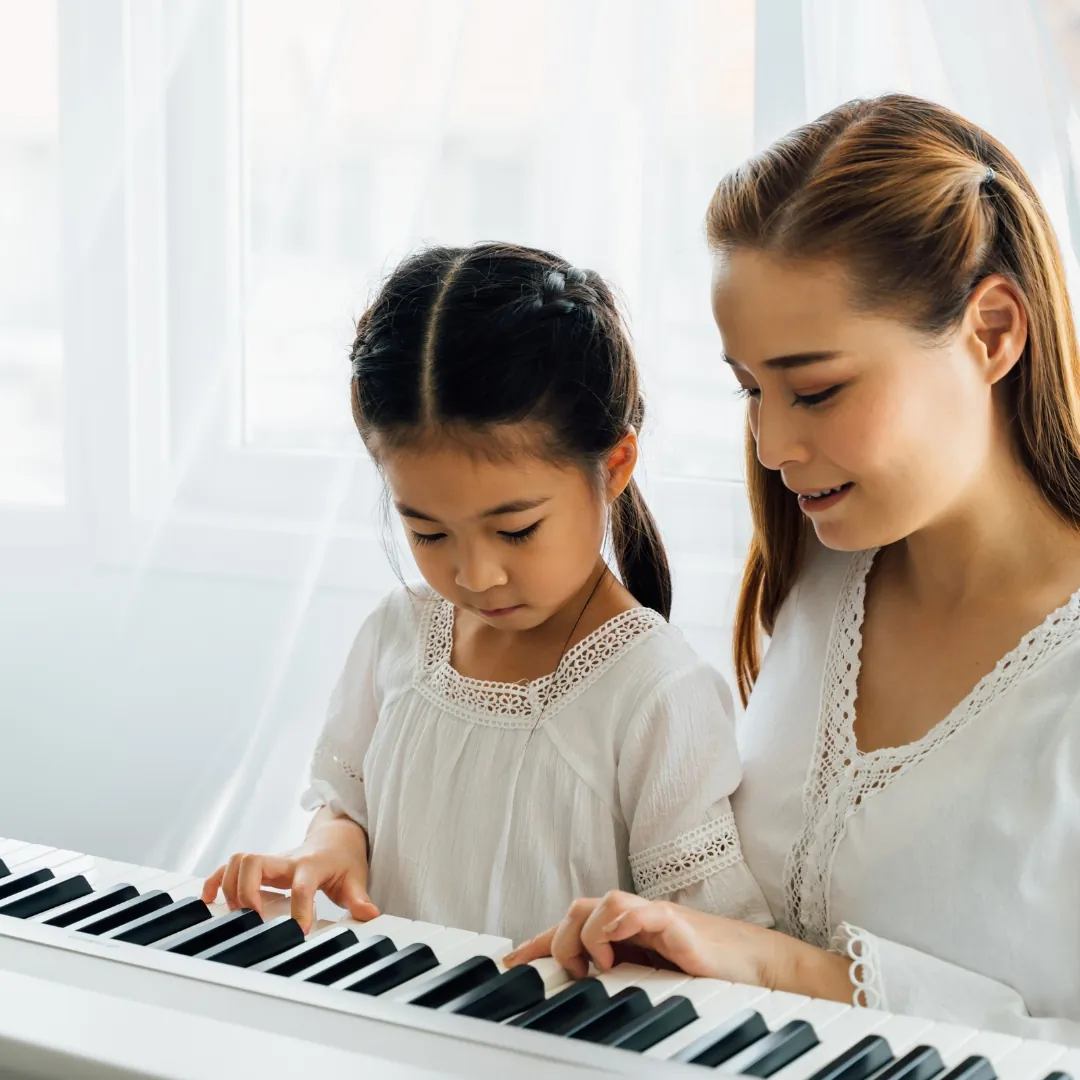 Music therapist helping a child play the piano. Music therapy for kids in Thornhill, Vaughan at Young Sprouts Therapy.