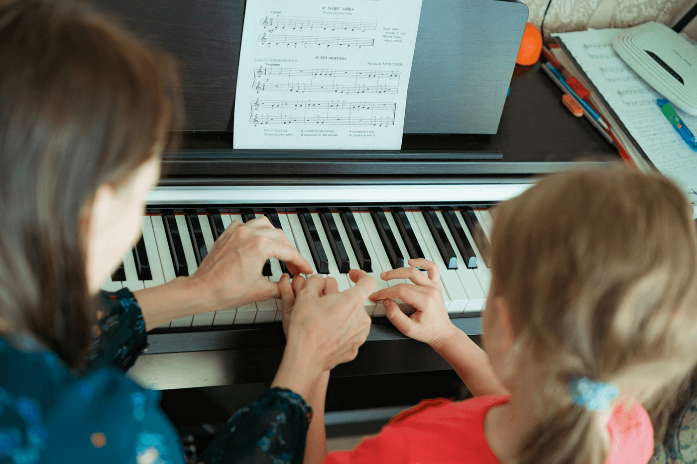 Therapist gently guiding a child’s hands on the piano during music therapy. Music therapy for kids and teens in Thornhill, Vaughan at Young Sprouts Therapy.