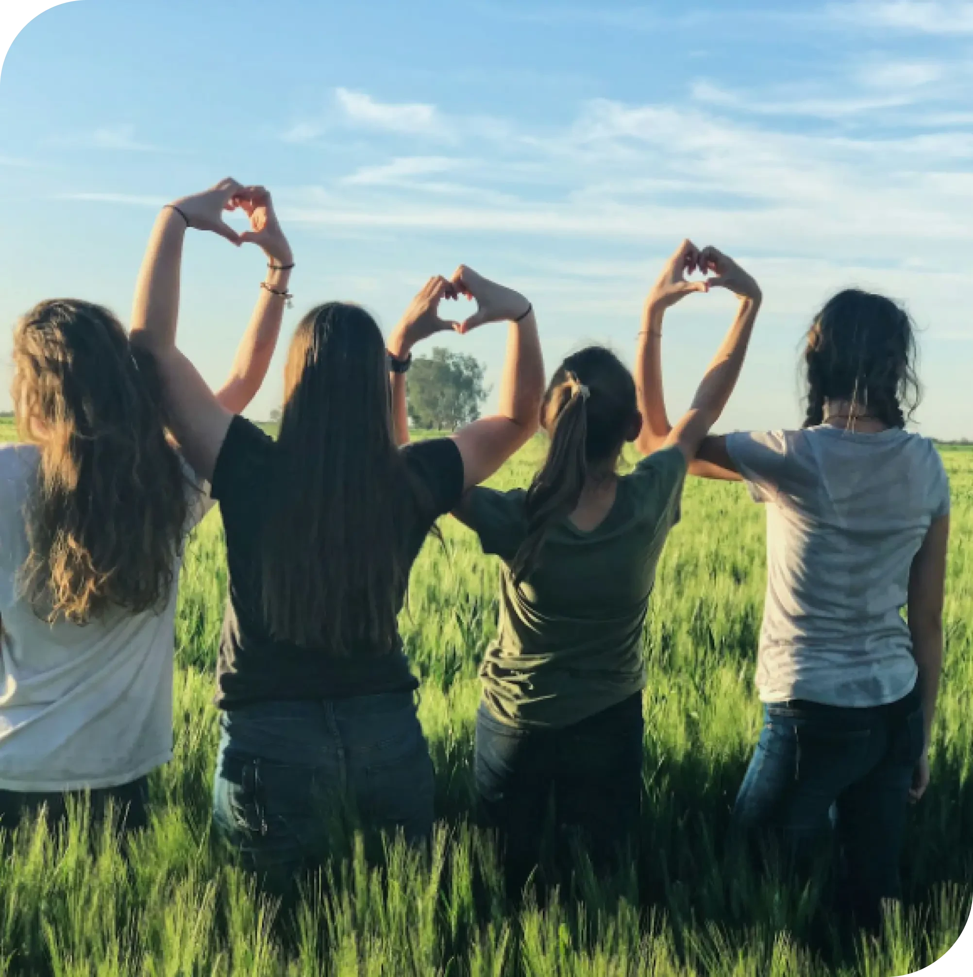 Group of women standing in a field, forming heart shapes with their hands, symbolizing support and growth through parenting counselling in Thornhill, Vaughan.