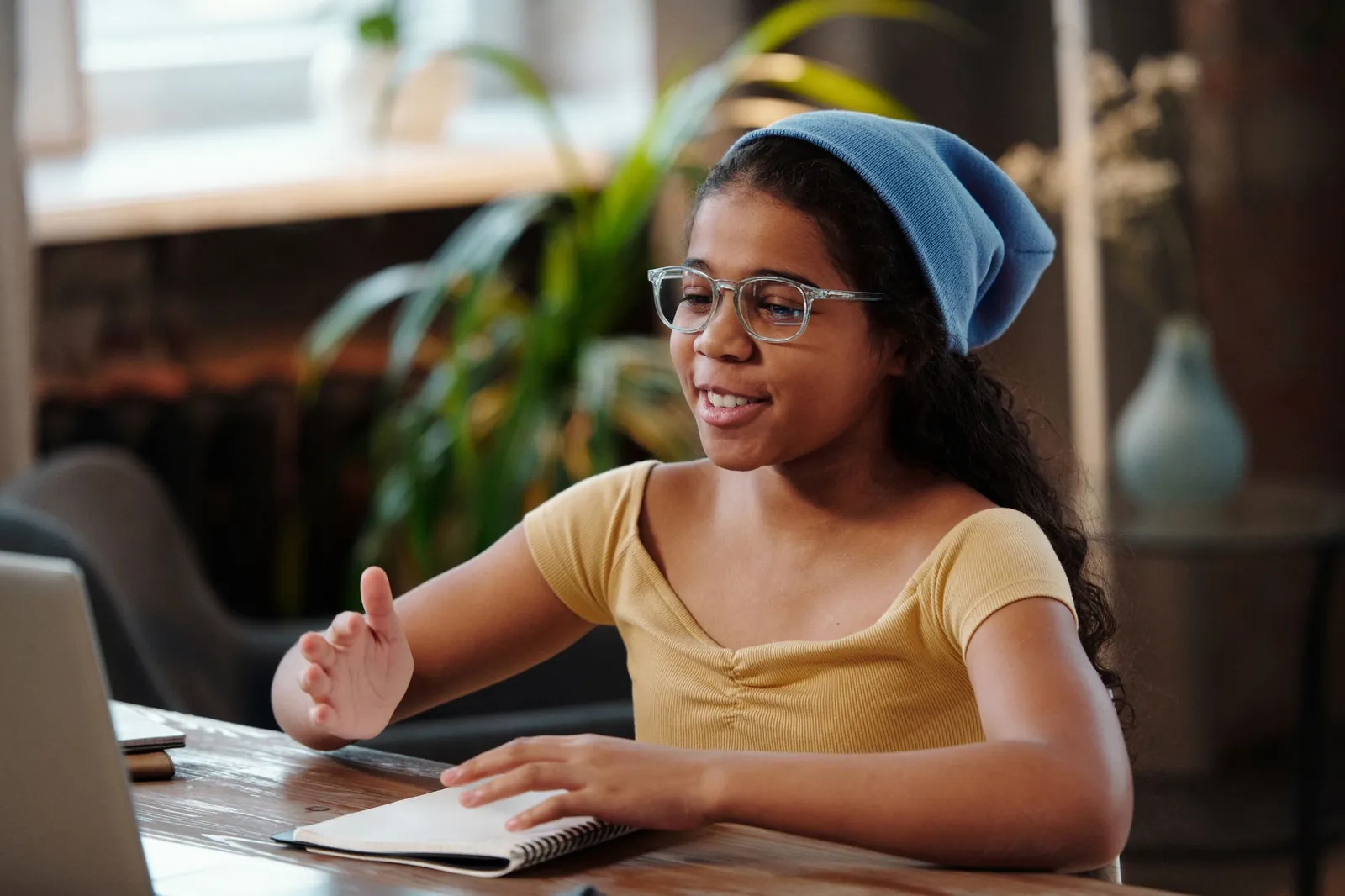 Teenager smiling and talking during a video session on a laptop at home