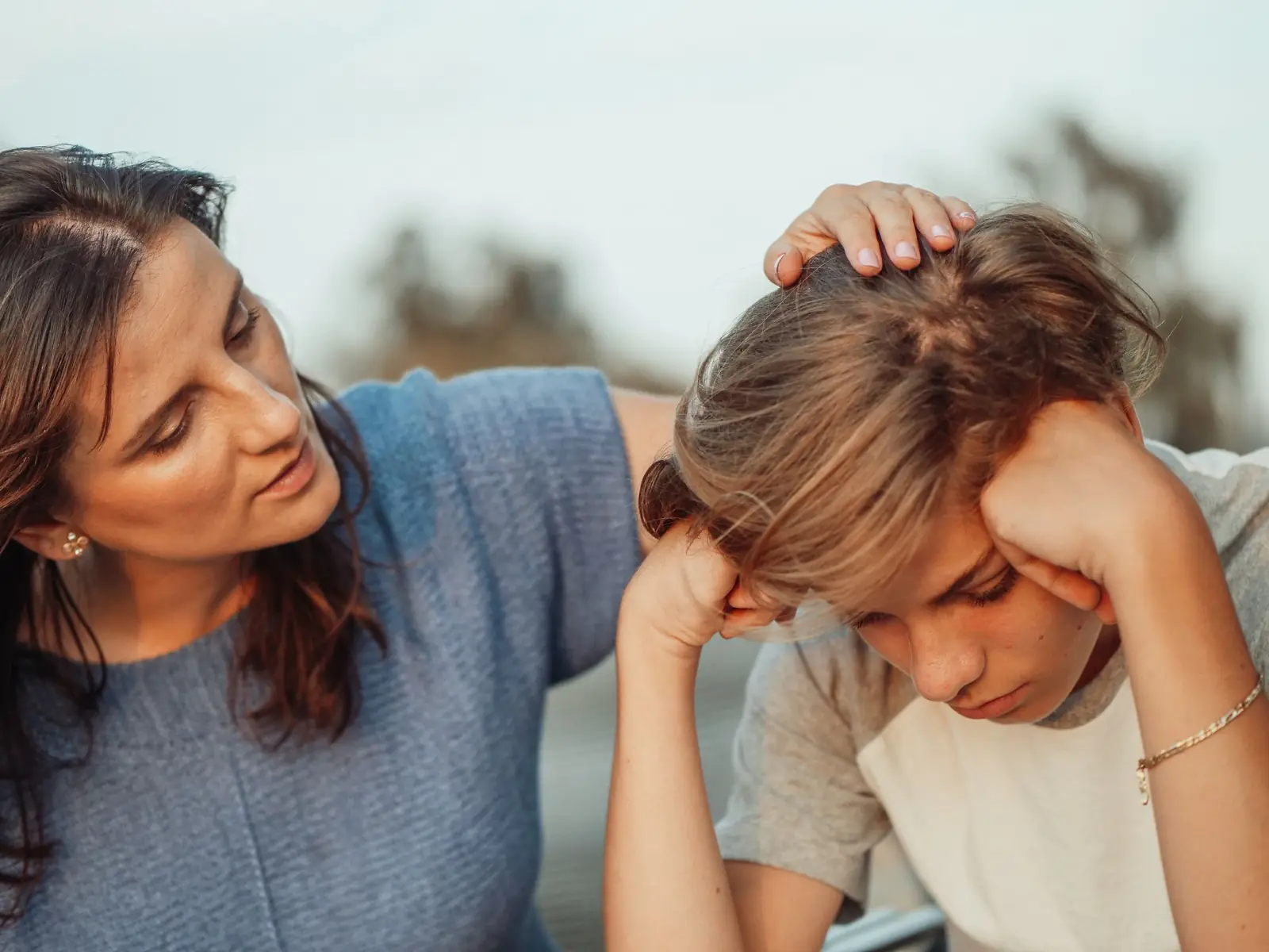 Parent comforting an upset child who may be getting bullied at school