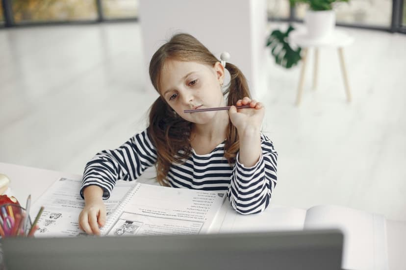 Young girl daydreaming at her desk — a common but missed sign of ADHD in girls Young girl daydreaming at her desk — a common but missed sign of ADHD in girls