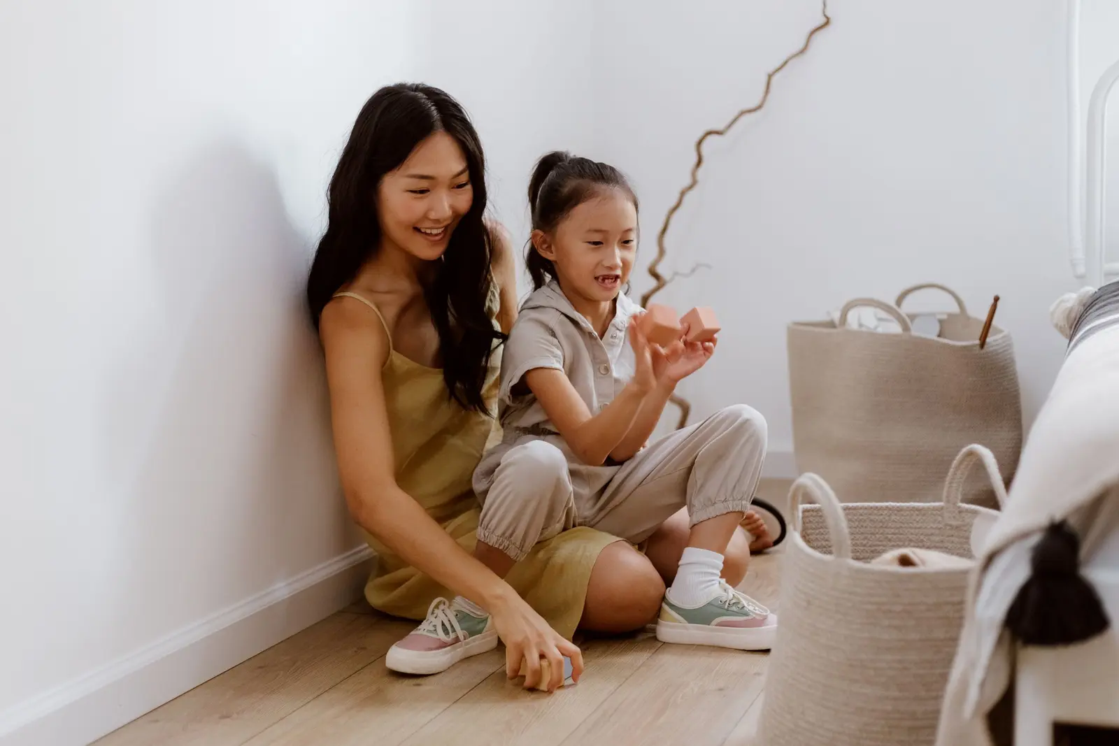 Parent and young child playing with wooden blocks on the floor