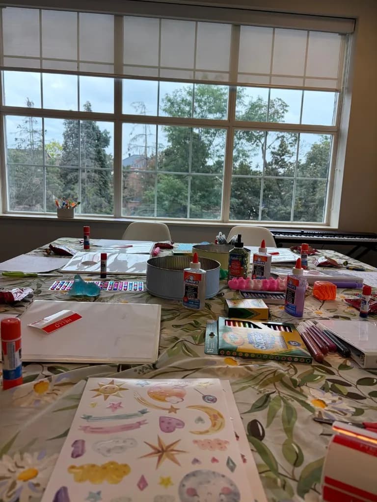 Young Sprouts Therapy Thornhill office workshop table set with binders, Crayola markers, glitter glue, and name tags for a tween vision board session