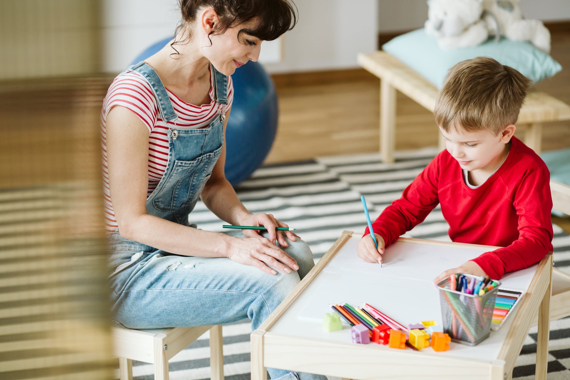 Occupational therapist helping a child practise handwriting and pencil control