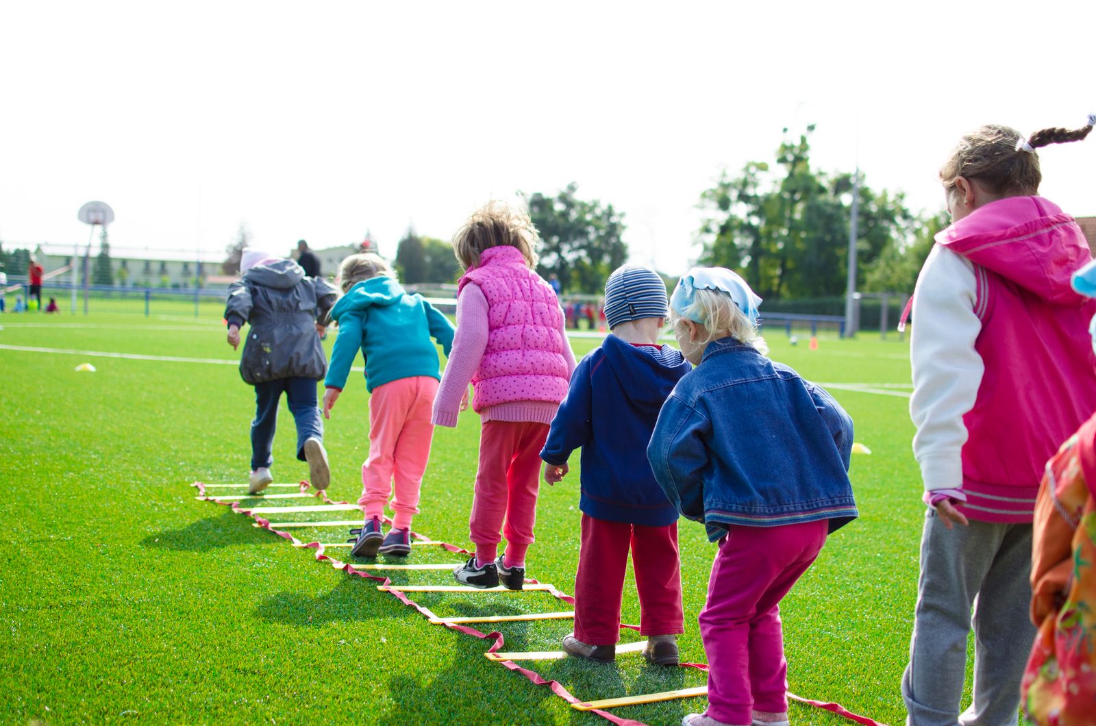 Children practising coordination and footwork on an agility ladder during gross motor activity