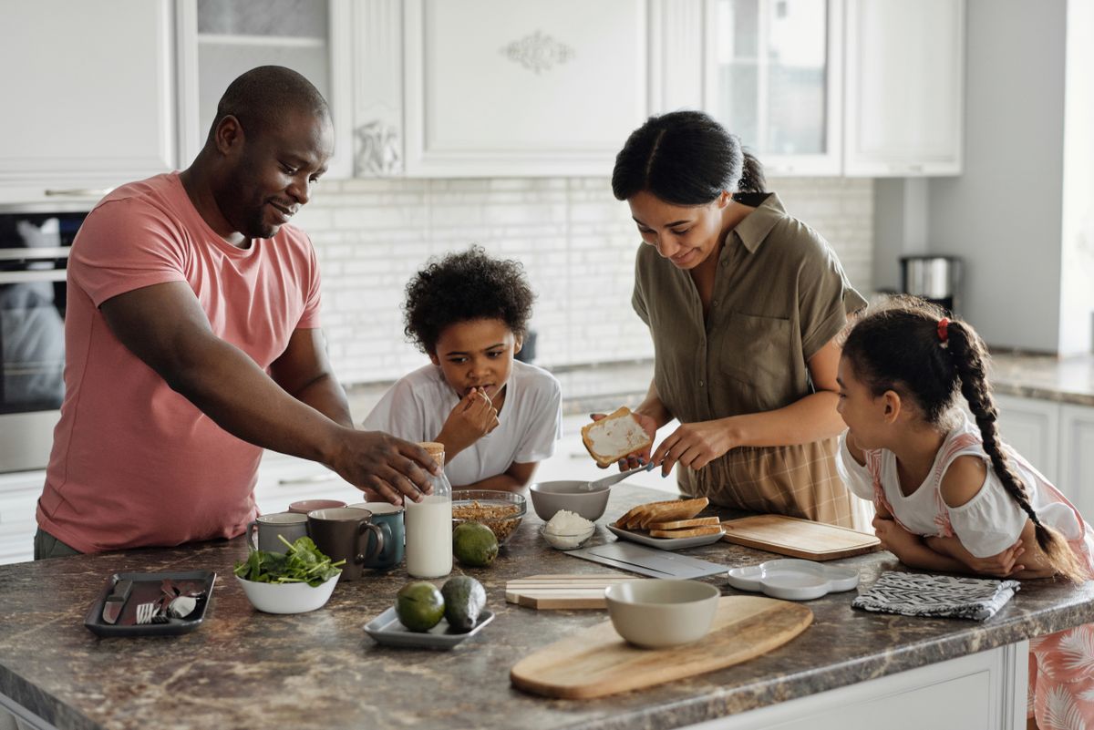 Family preparing breakfast together in the kitchen, supporting pediatric feeding and mealtime routines