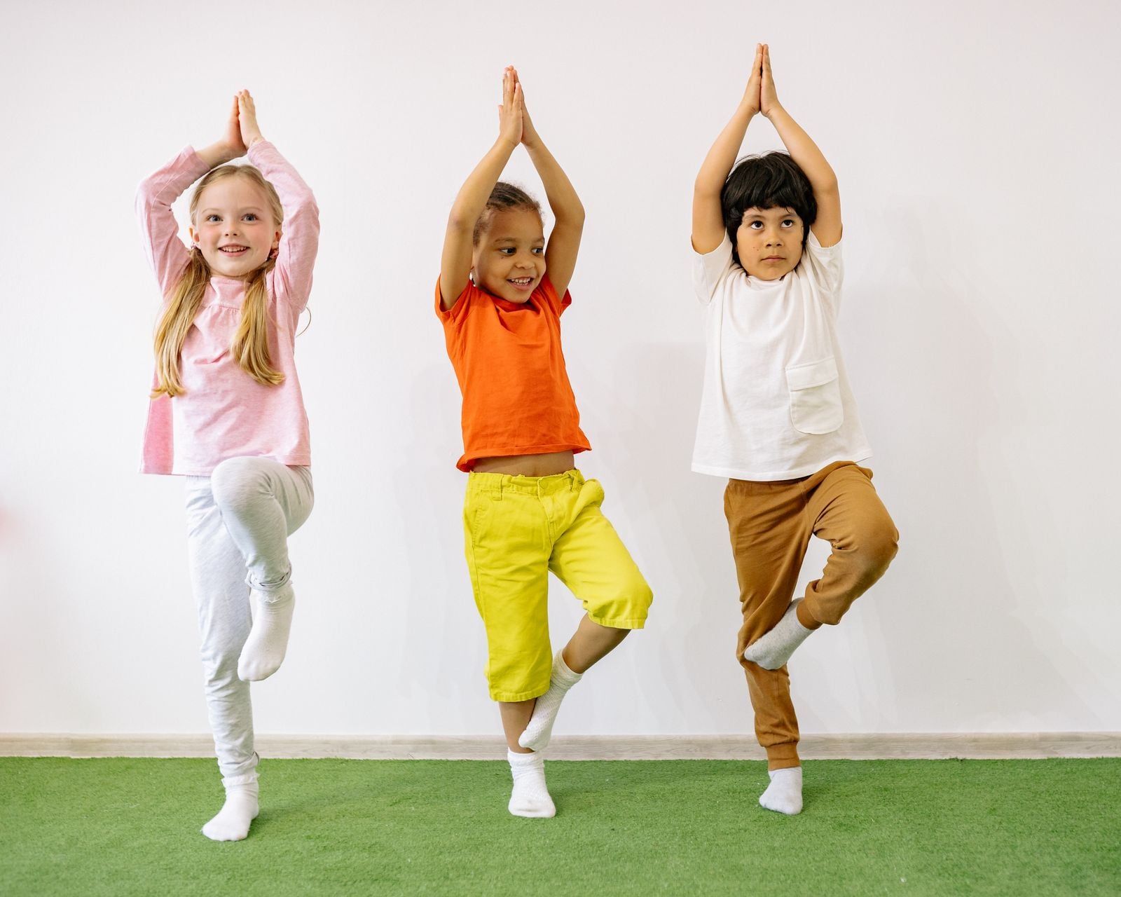 Children practising balance and body control in a tree-pose activity during pediatric OT