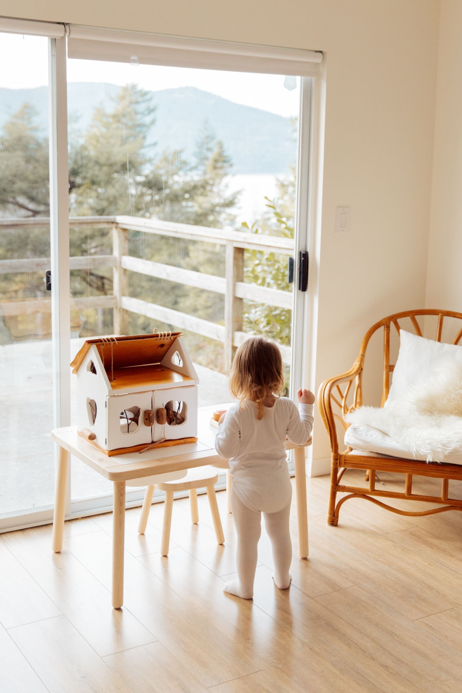 Toddler practising fastening and hand skills with a latching activity house