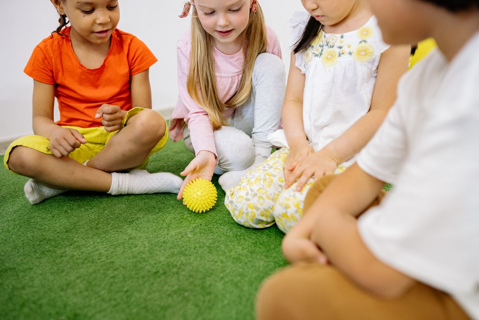 Children exploring a spiky sensory ball together during a pediatric OT sensory activity