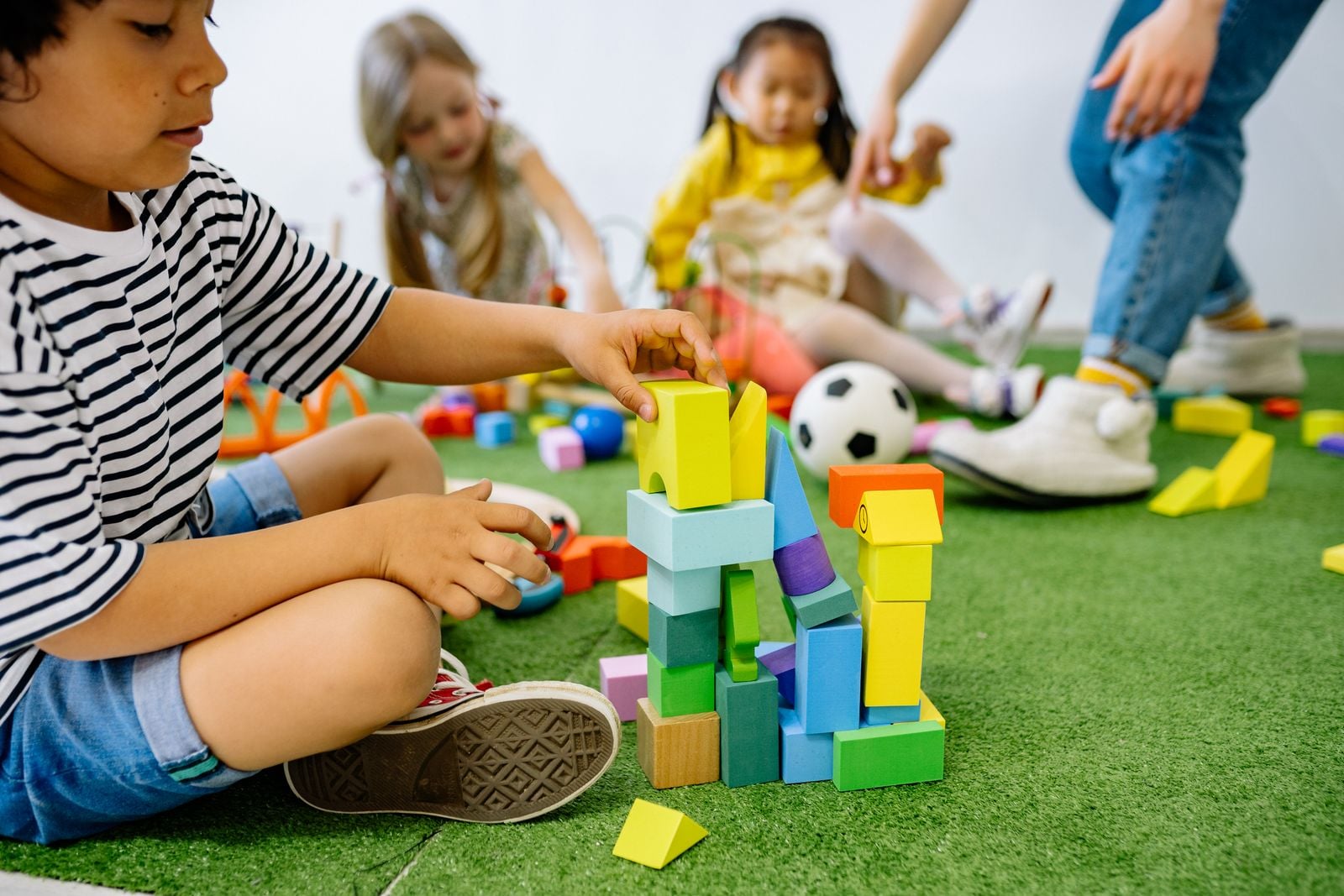 Child building a tower with colourful foam blocks to practise visual-spatial skills
