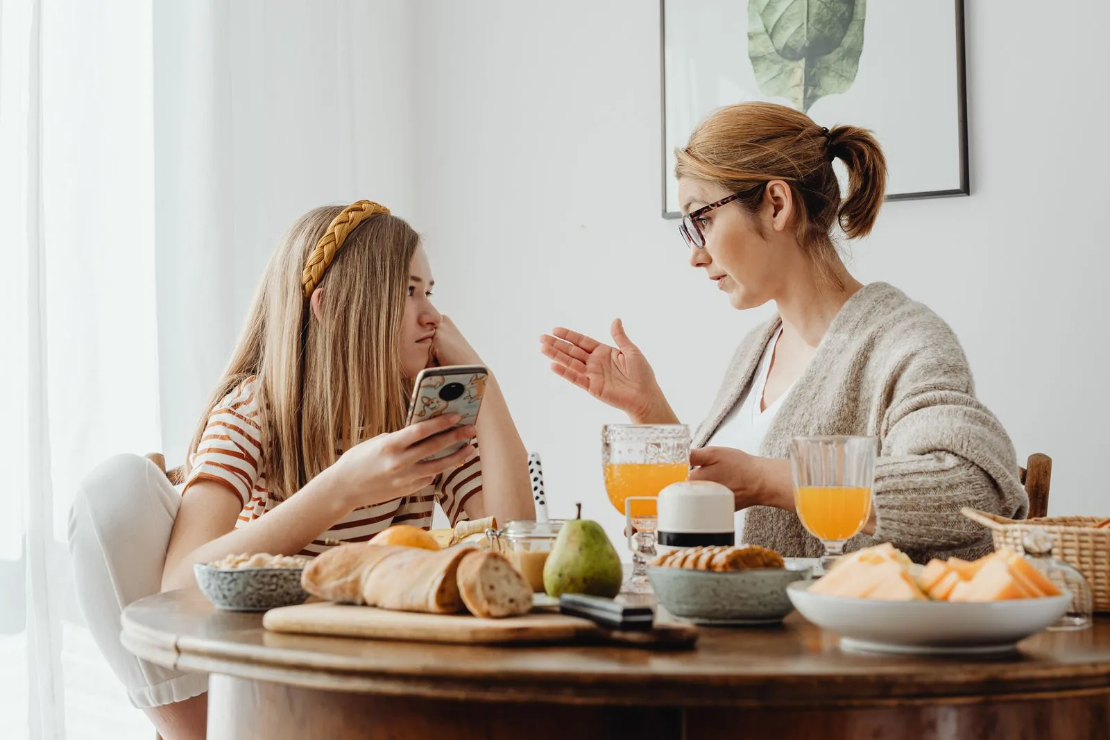 Parent and teenager having a calm conversation at the kitchen table about getting support