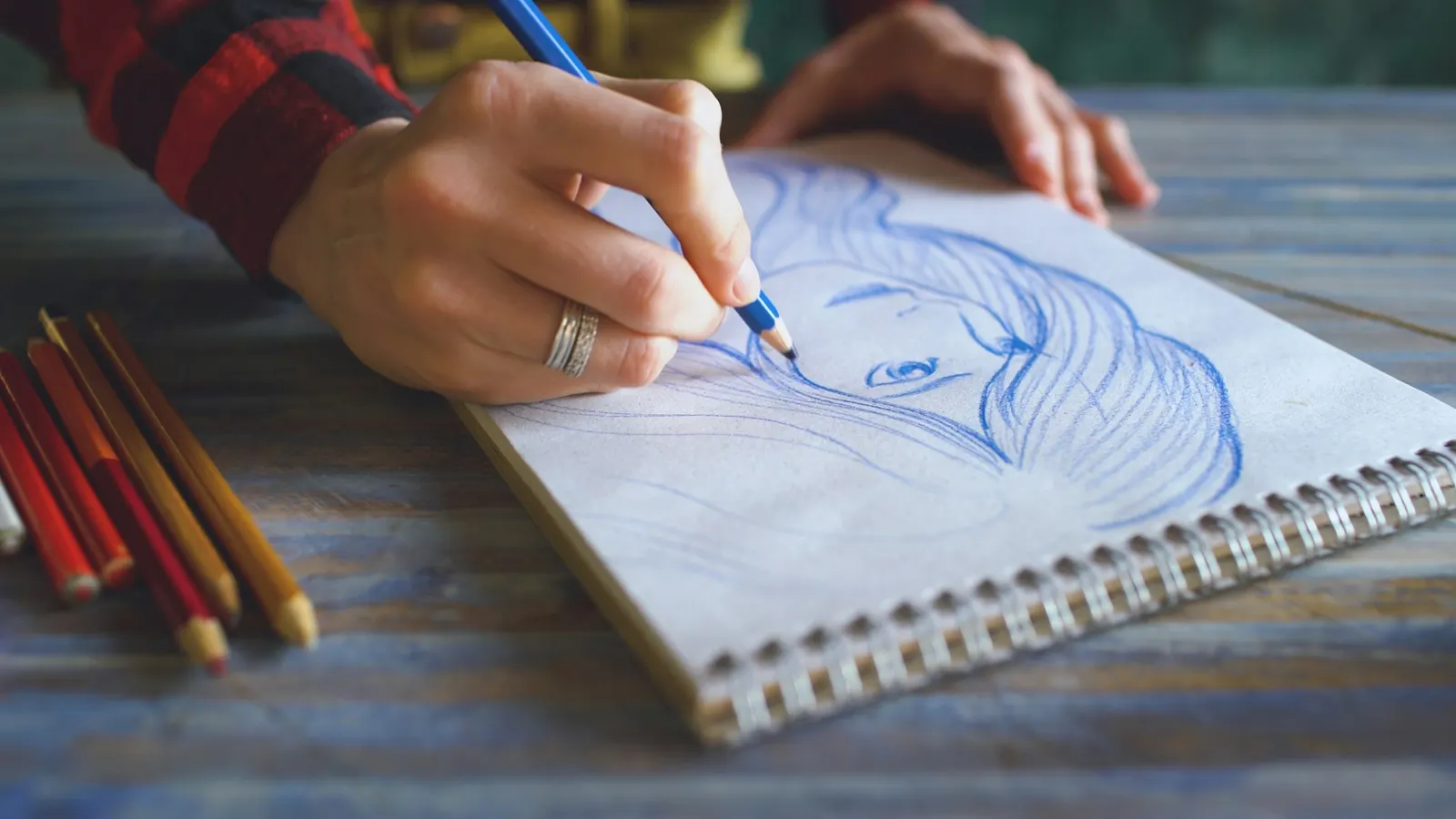 Teen sketching in a notebook, where dark themes are often a normal form of self-expression