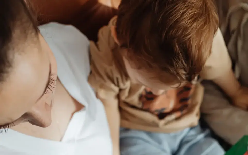 Parent and child reading a picture book together